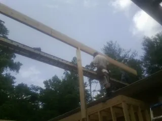Carpenter setting a ridge beam over a new addition frame — Ice Dam Removal by Roofing Brothers in Granite Springs