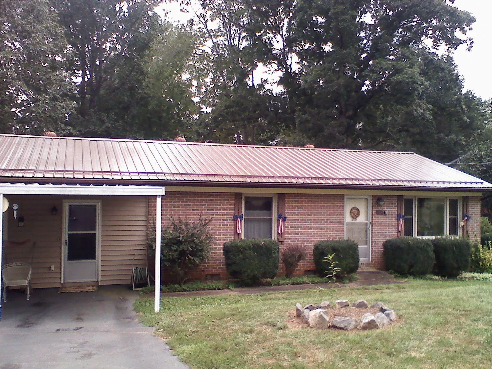 Bronze metal roof and carport on a brick ranch home — Roof Repair work by our crew in Granite Springs